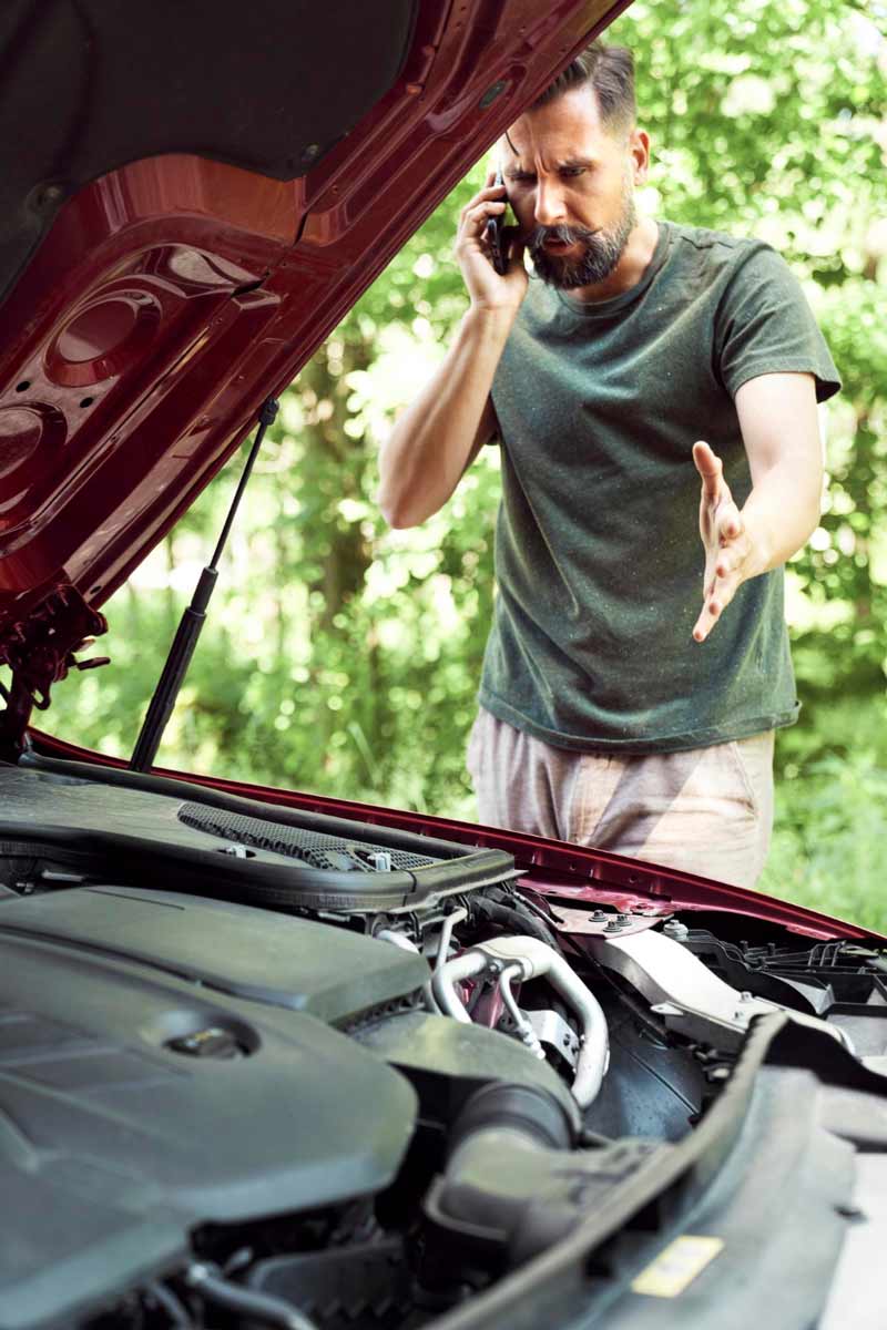 Junger Mann prüft Getriebeschaden bei Schrottauto Ankauf Göttingen